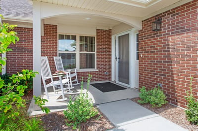 Front entrance with rocking chairs and flowers
