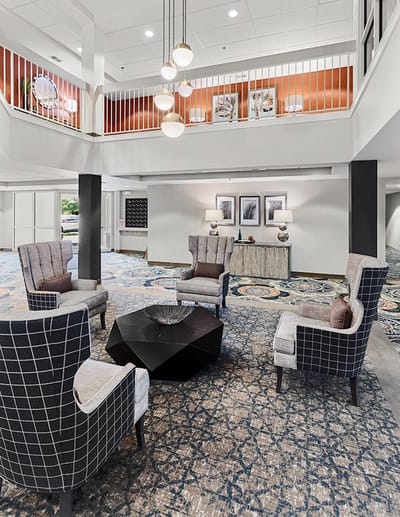 Interior common area with upholstered chairs and a decorative table