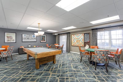 Interior activity room with pool table and seating