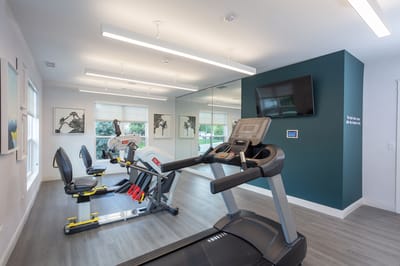 Modern gym area with exercise equipment and mirrors