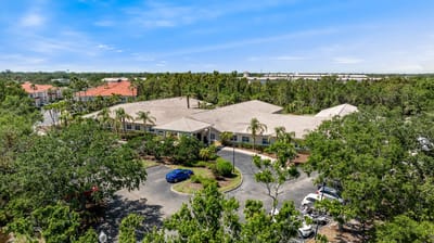 Aerial view of Aston Gardens at Pelican Pointe surrounded by greenery