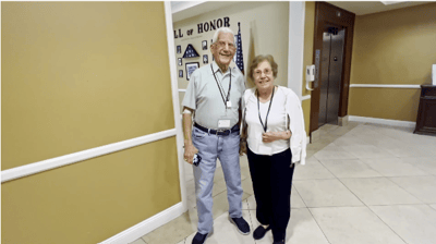 Two residents smiling in a facility hallway