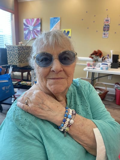 Smiling resident wearing sunglasses and jewelry in a common area