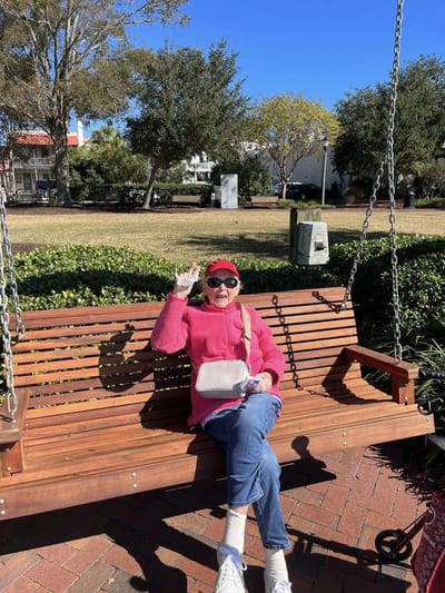 A resident enjoying a sunny day on a swing in the garden