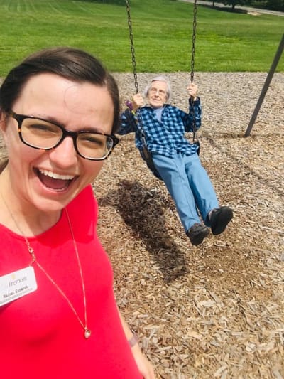 Staff member and resident enjoying swings outside