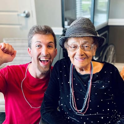 Resident and staff member celebrating together with smiles