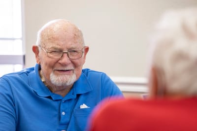 Senior man smiling while engaging in conversation