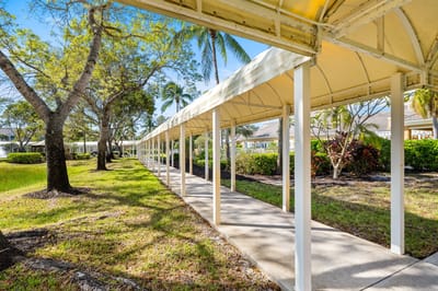 Covered walkway leading through a garden area
