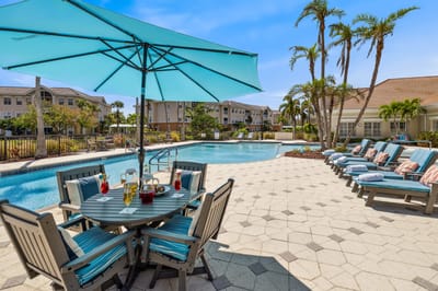 Outdoor pool area with seating and umbrellas