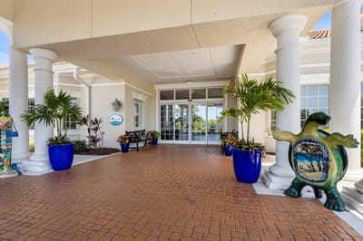 Entrance of Aston Gardens at Pelican Pointe with colorful decor