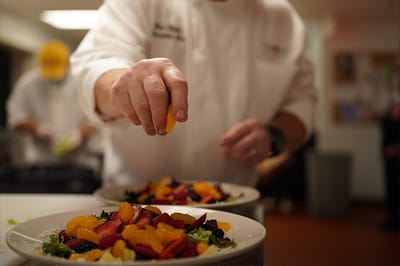 Chef preparing a fresh fruit salad in the kitchen