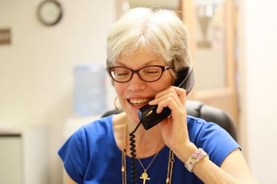 Staff member speaking on the phone in a facility office