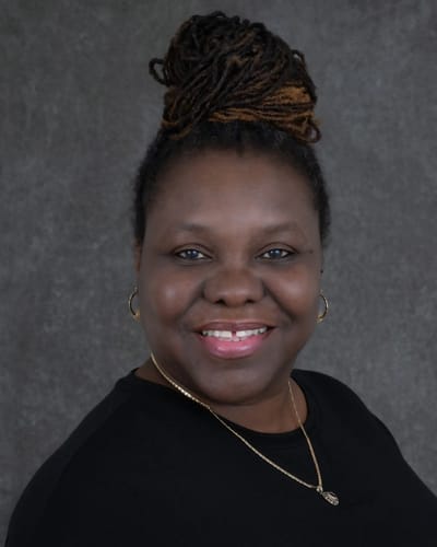 Avery Heights Assisted Living and Memory Care, independent living in Hartford, CT — Smiling woman with braided hair against a gray backdrop