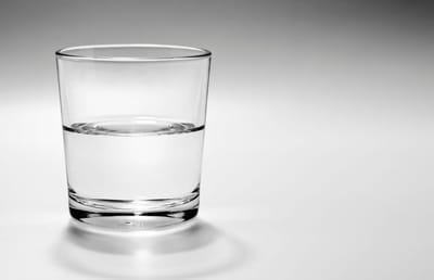 A glass of water on a plain background