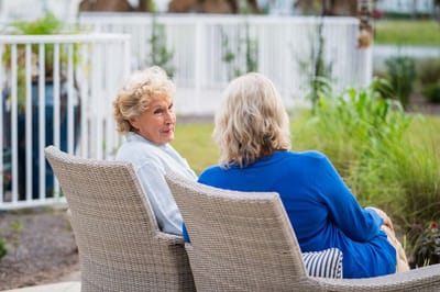 Two women chatting in a garden setting