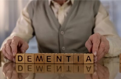 Meadowcrest – Middletown, Assisted Living in Middletown, DE — Hands arranging wooden blocks spelling 'DEMENTIA