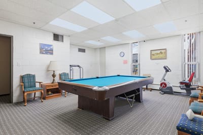 Activity room with a pool table and exercise equipment