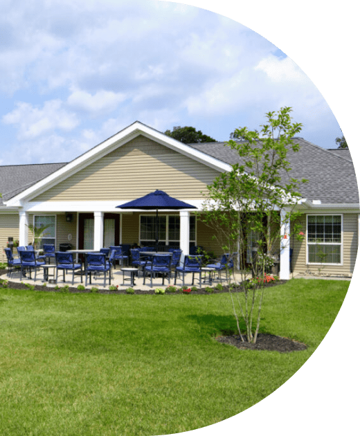 Exterior view of a senior living building with outdoor seating