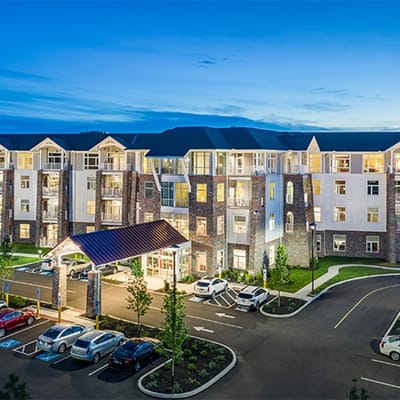 Exterior view of a senior living facility at dusk
