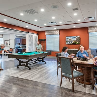 Residents enjoying a game room with pool table