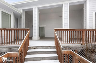 Outdoor porch area with wooden railing and snow