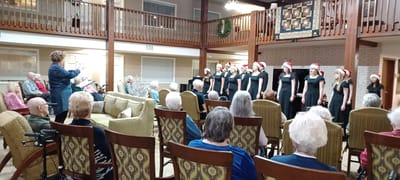 Residents watching a Christmas choral performance in a common area