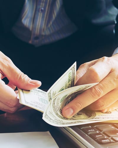 Hands counting money on a table