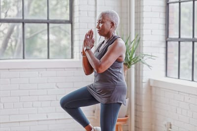 An older adult practicing yoga in a bright interior space