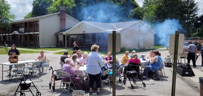 Residents enjoying an outdoor gathering with tables