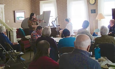 Residents enjoying a music performance in a common area