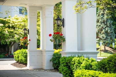 Entrance of the facility with flowering plants and greenery