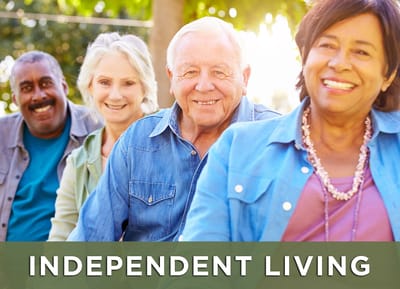 Four residents smiling outdoors in casual attire