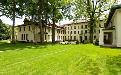 Exterior view of the facility surrounded by trees and lawn