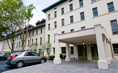 Exterior view of a senior living facility with a car parked