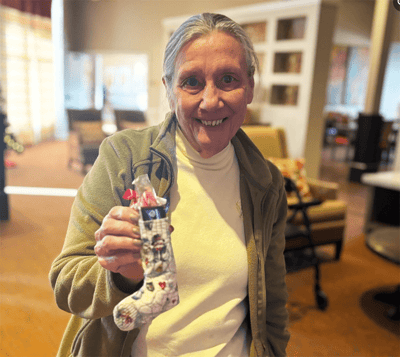 Resident holding a festive stocking in a cozy common area