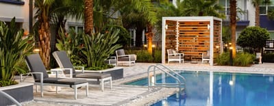 Outdoor pool area with lounge chairs and greenery