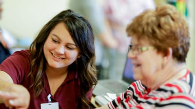 Staff member engaging with a resident in a communal space