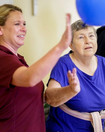 Staff member and resident engaging with a balloon activity