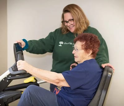 Staff assisting a resident on a therapeutic device