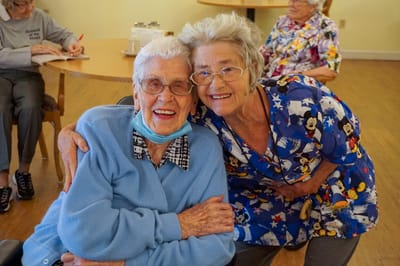 Two smiling residents posing for a photo in common area