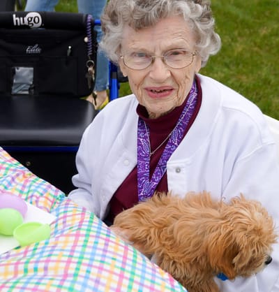 Elderly woman with a small dog during an outdoor activity
