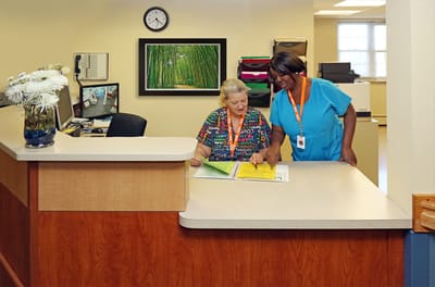 Staff assisting a resident at the reception desk