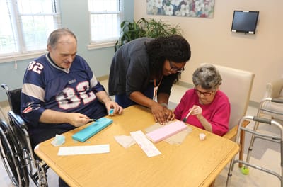 Residents engaging in an arts and crafts activity with staff