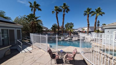 View of outdoor pool area with seating and palm trees