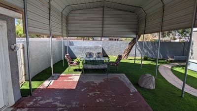 Covered patio area with seating in a garden