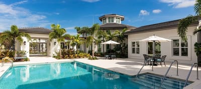 Outdoor pool area with palm trees and seating