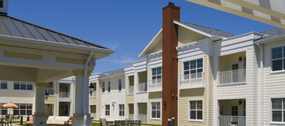 View of the exterior of a senior living facility with outdoor seating