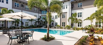 Outdoor pool area with seating and palm trees