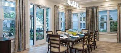 Bright dining room with large windows and tables set for meals