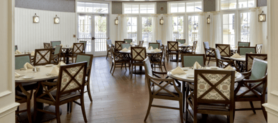 Dining room with neatly set tables and chairs.